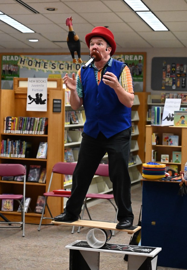 Gregory May performs a juggling and balancing routine as part of his Circus Science act at the North Carroll Branch library on Thursday. May, a Columbia resident, combines science and circus tricks to educate and entertain her audiences through the background of a former Ringling Brothers circus performer Barnum and Bailey, a science teacher in Baltimore City and an instructor at Port Discovery. (Brian Krista/staff photo)